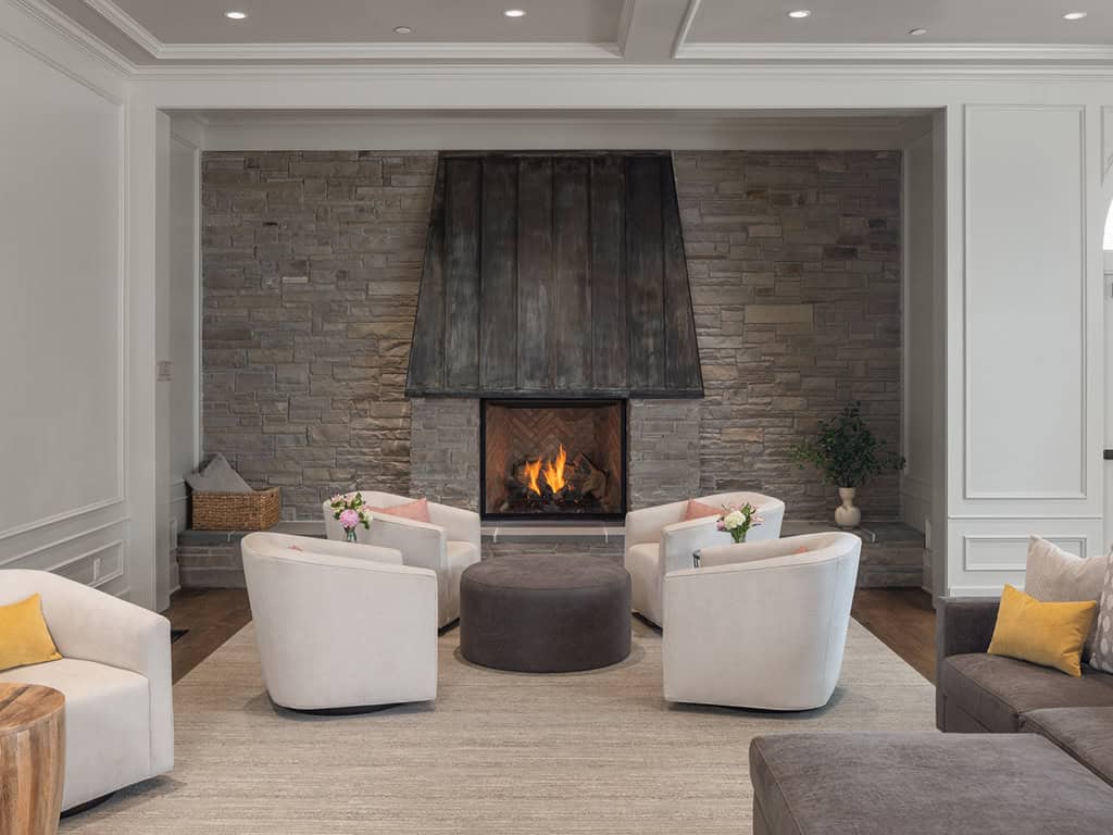 Cozy lounge area with a fireplace and white chairs